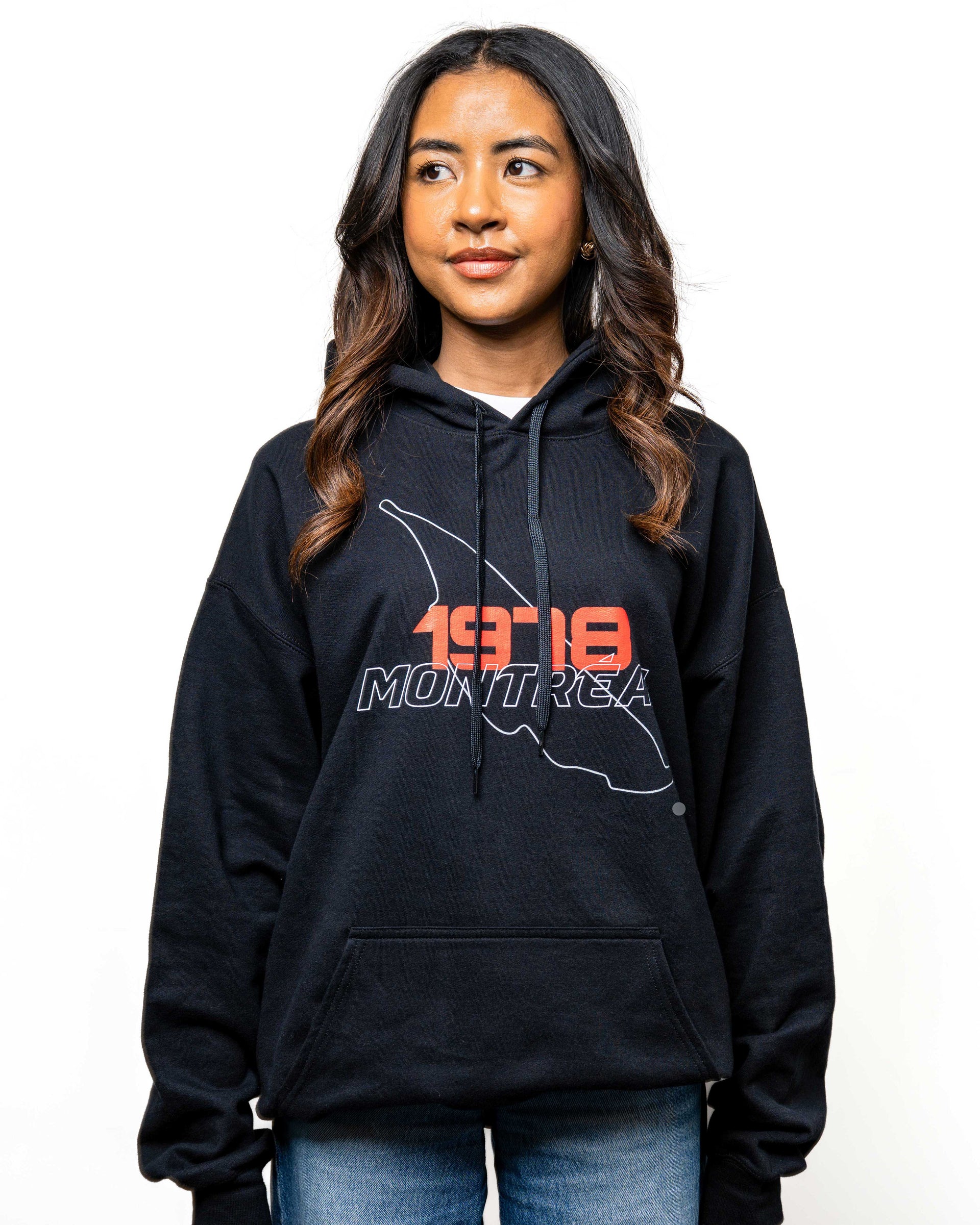 Modèle femme portant le hoodie noir ‘1978’, vue de face, mettant en avant l’impression rouge et blanche sur la poitrine.