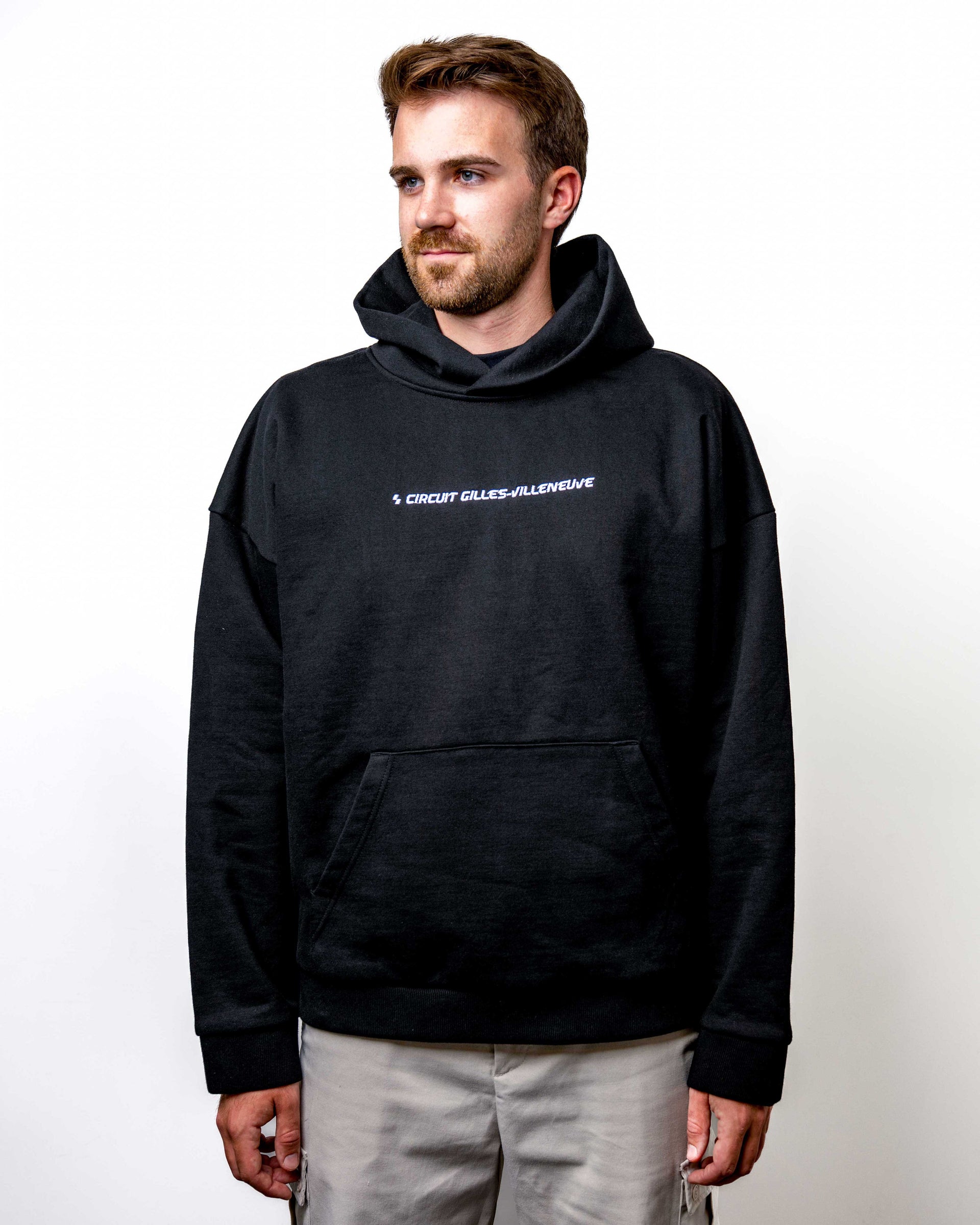 Vue de face du hoodie noir ‘Salut Gilles’ porté par un modèle homme, mettant en avant le design épuré et la coupe décontractée.