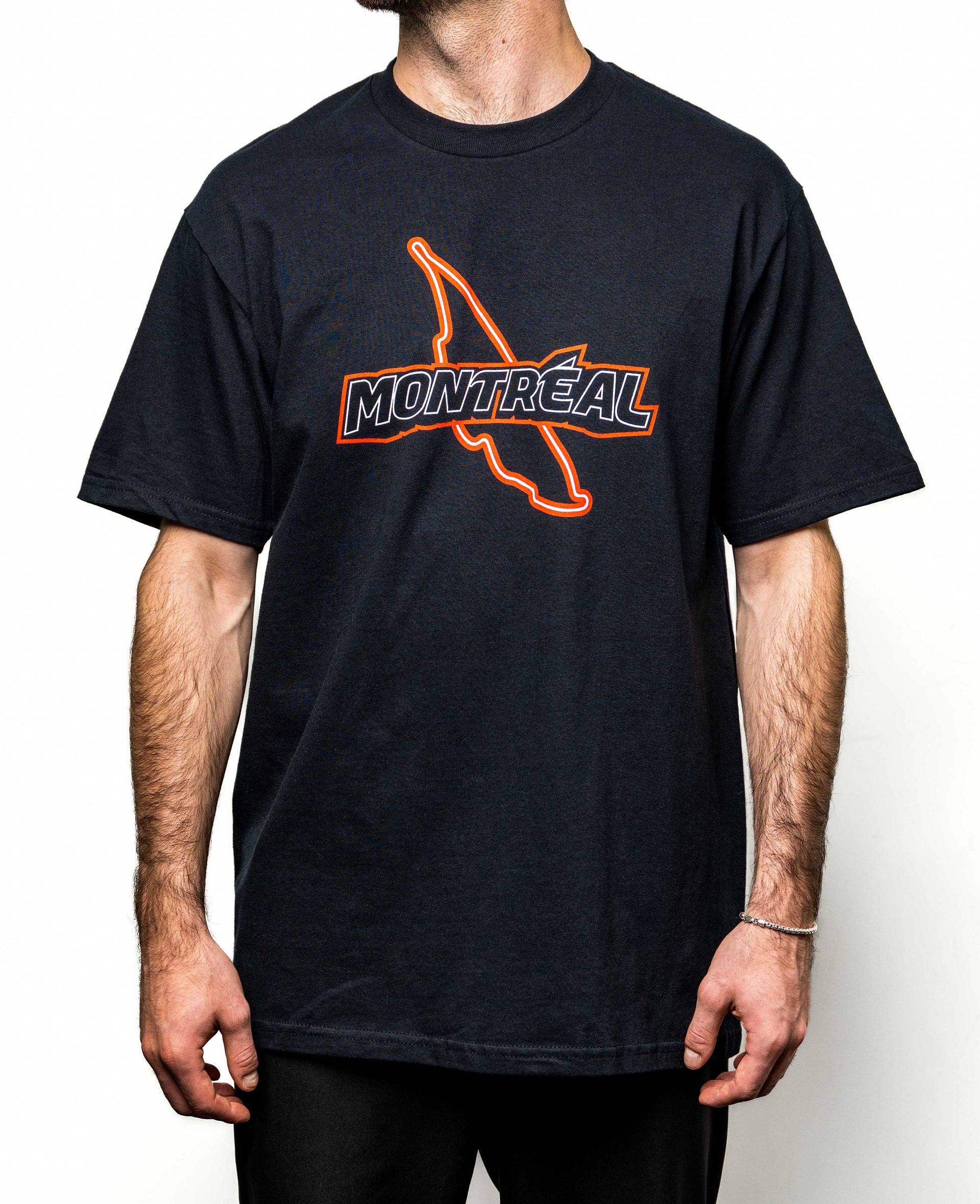 Modèle homme portant un t-shirt noir avec illustration rouge du circuit et lettrage Montréal.