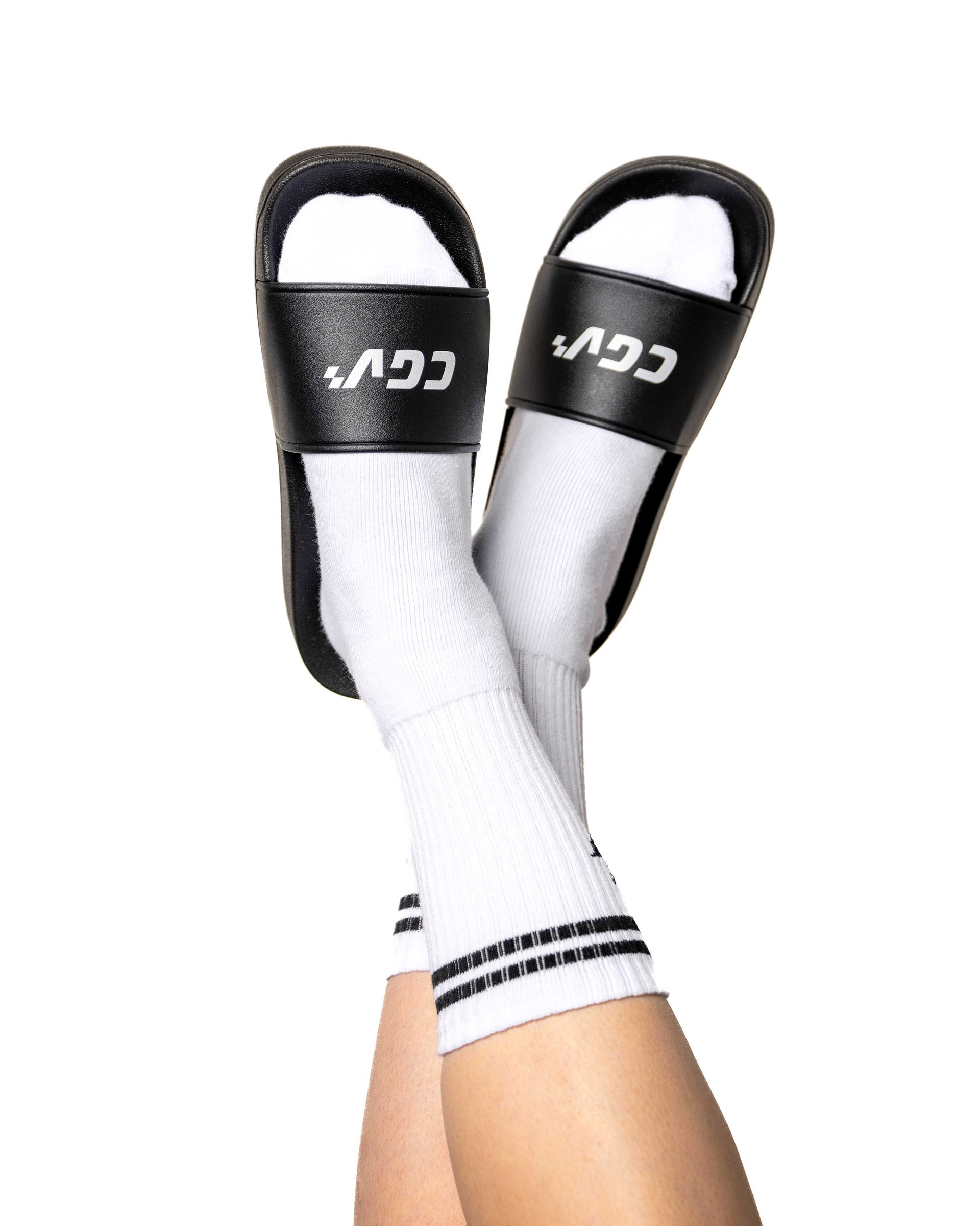 Jambes portant des sandales CGV noires avec chaussettes blanches, vue de face.