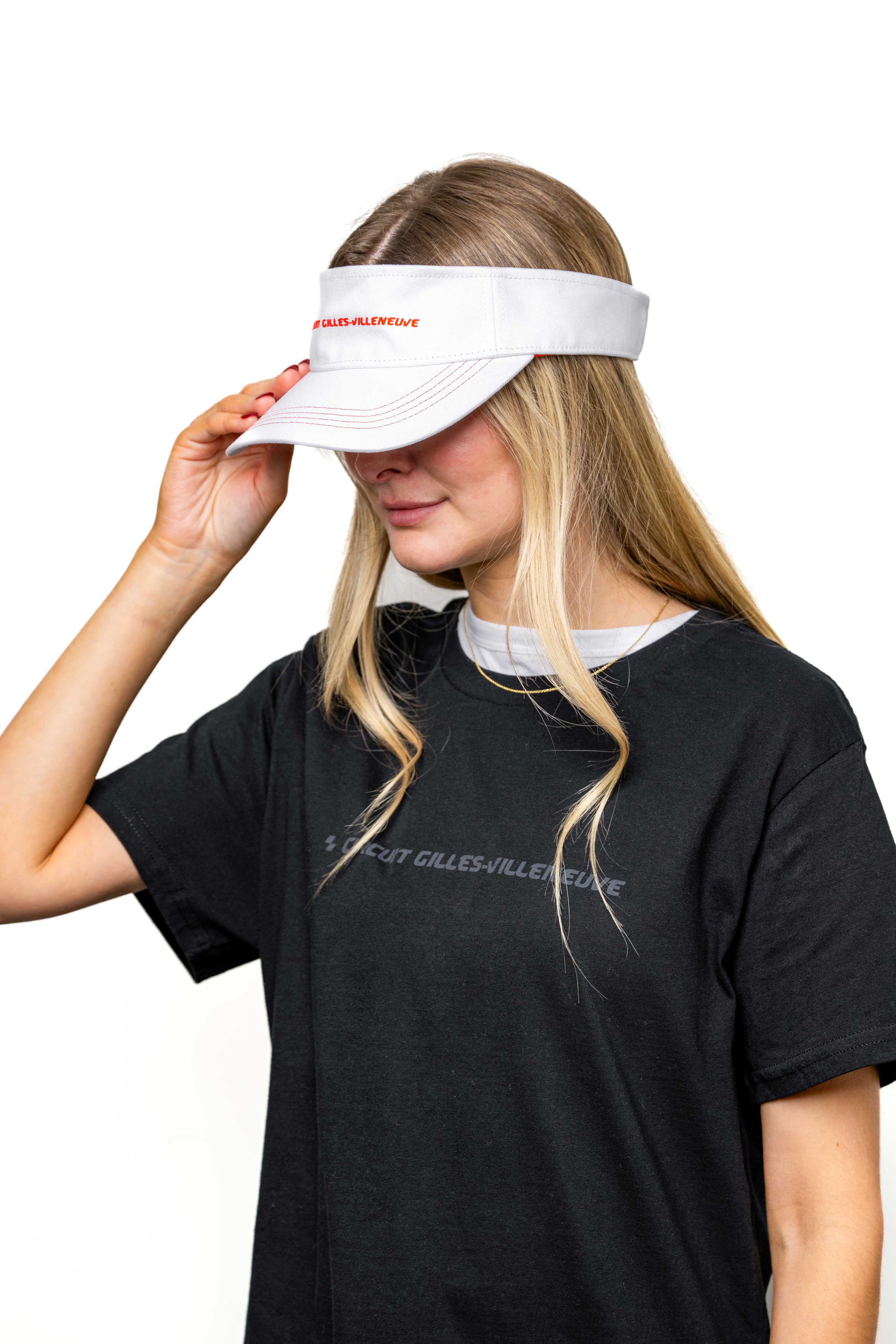 Modèle femme portant une visière blanche à liseré rouge avec logo brodé, vue de profil.