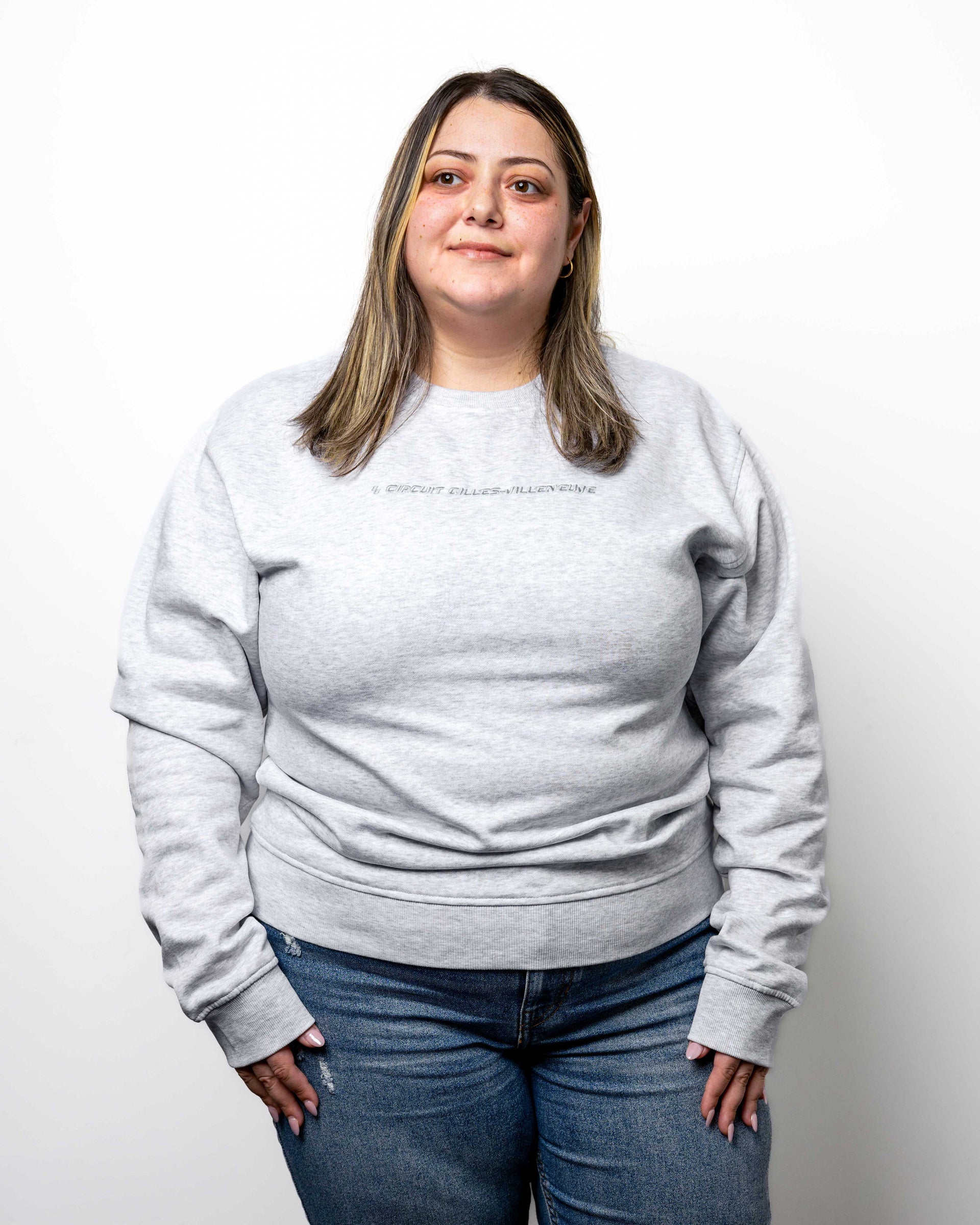 Modèle femme portant le crewneck gris, vue de face, illustrant la coupe ample et confortable.