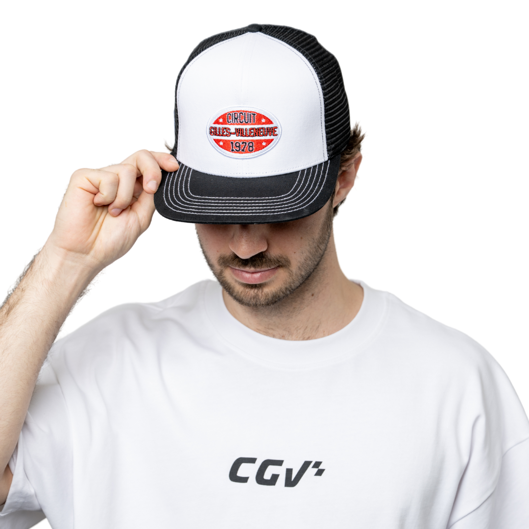Modèle homme baissant la tête en tenant la visière d'une casquette trucker blanche avec patch rouge CGV.